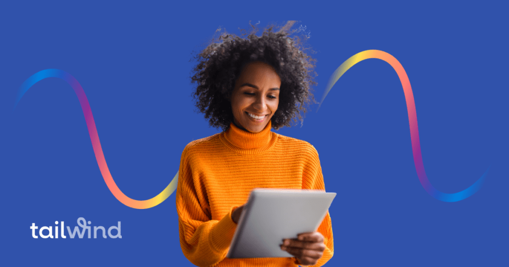 Photo of a woman working on a tablet and smiling on a blue background with the word Tailwind in white font.